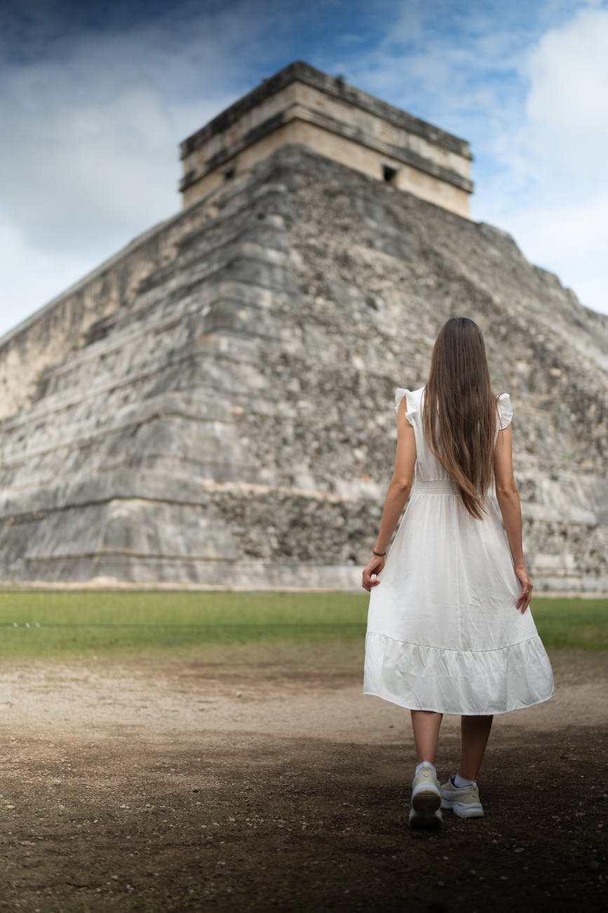 woman in white dress standing near a pyramid